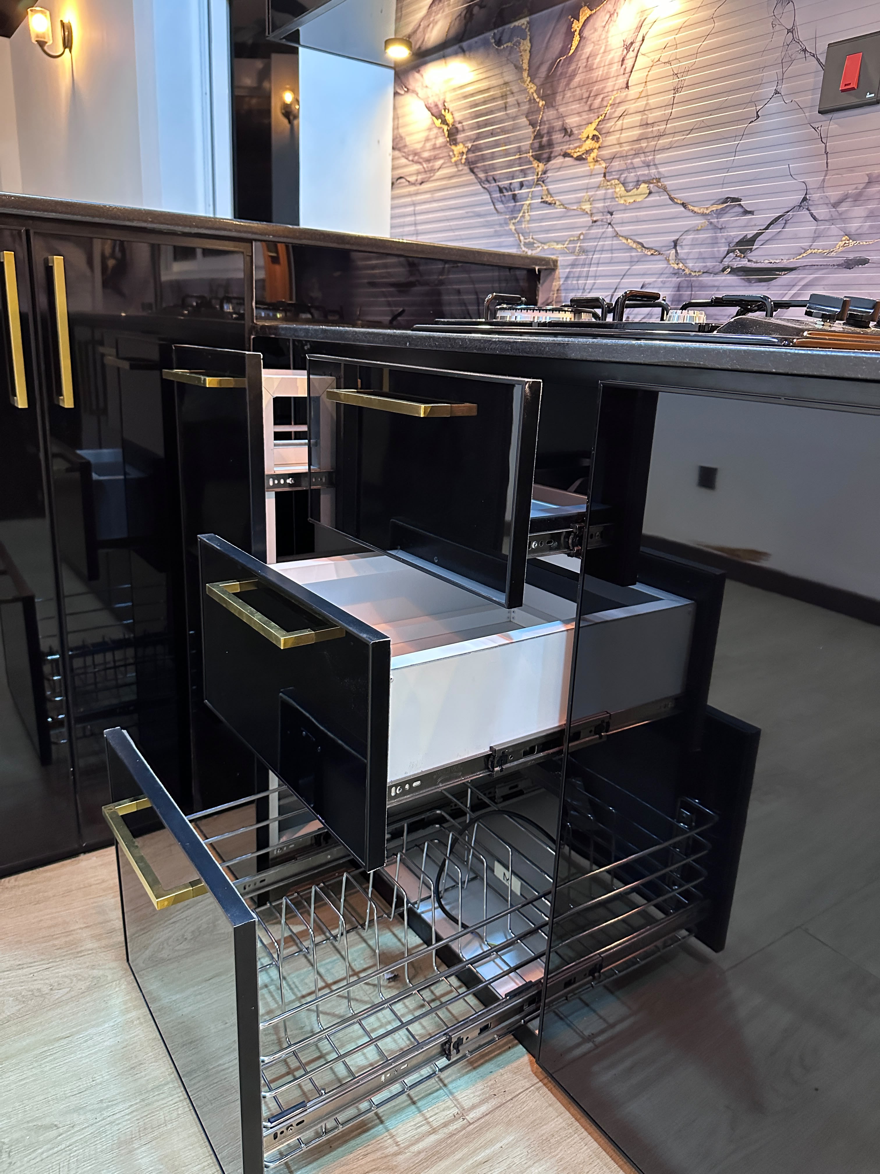 Black aluminium kitchen cabinets with gold handles and drawer mechanisms